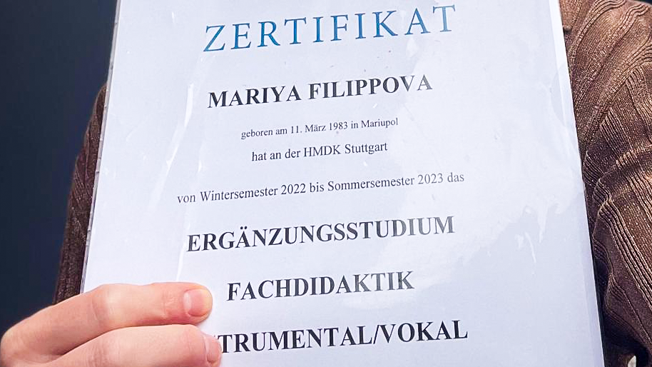 Mariya Filippova hält ihr Zertifikat zum Ergänzungsstudium "Fachdidaktik" in Händen.